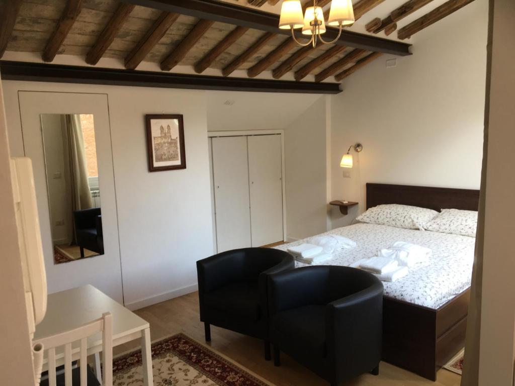 um quarto com uma cama, uma cadeira e uma mesa em Montoro 15 Attic Suite em Roma