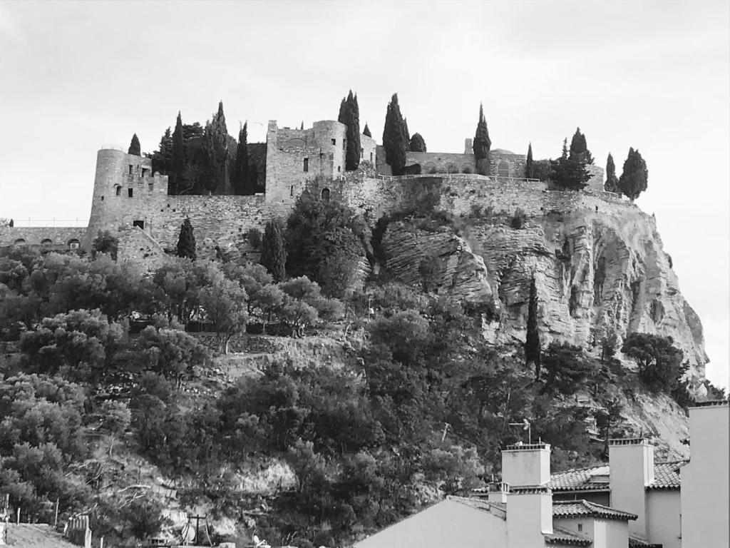 a black and white photo of a castle on a hill at Hôtel Liautaud Rooftop Cassis in Cassis