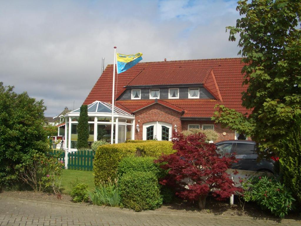 una casa con una bandera encima en Haus Delphin, en Neuharlingersiel