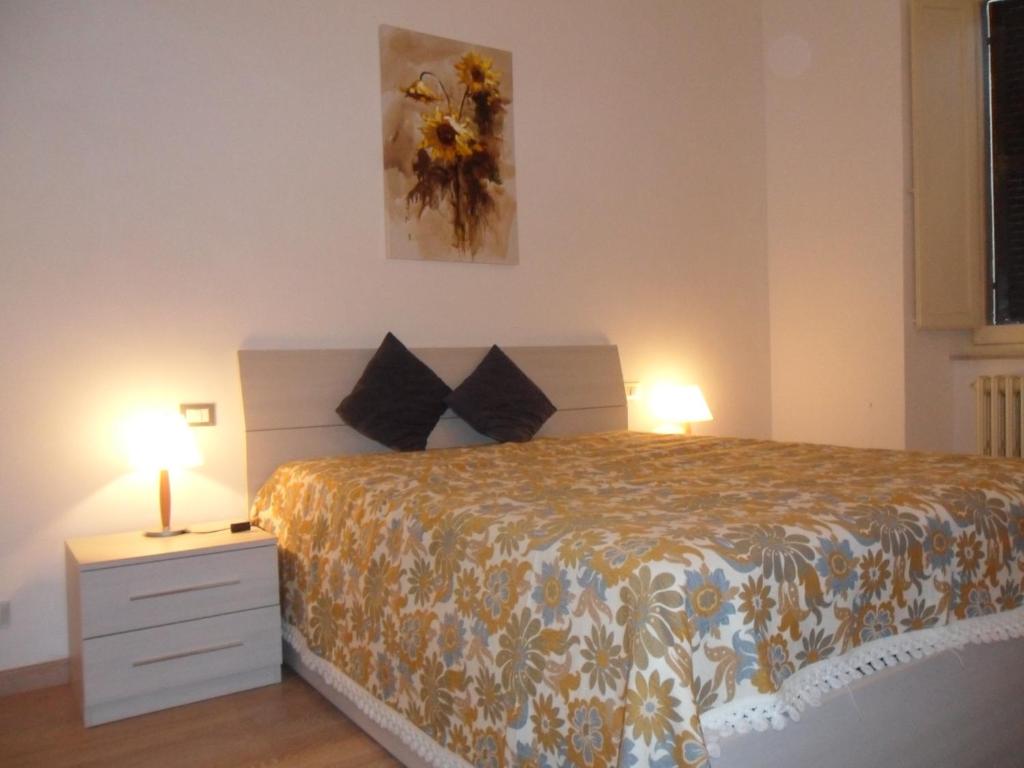 ein Schlafzimmer mit einem Bett und zwei Lampen auf einem Nachttisch in der Unterkunft Casa Maria e Casa Cristina in Orvieto