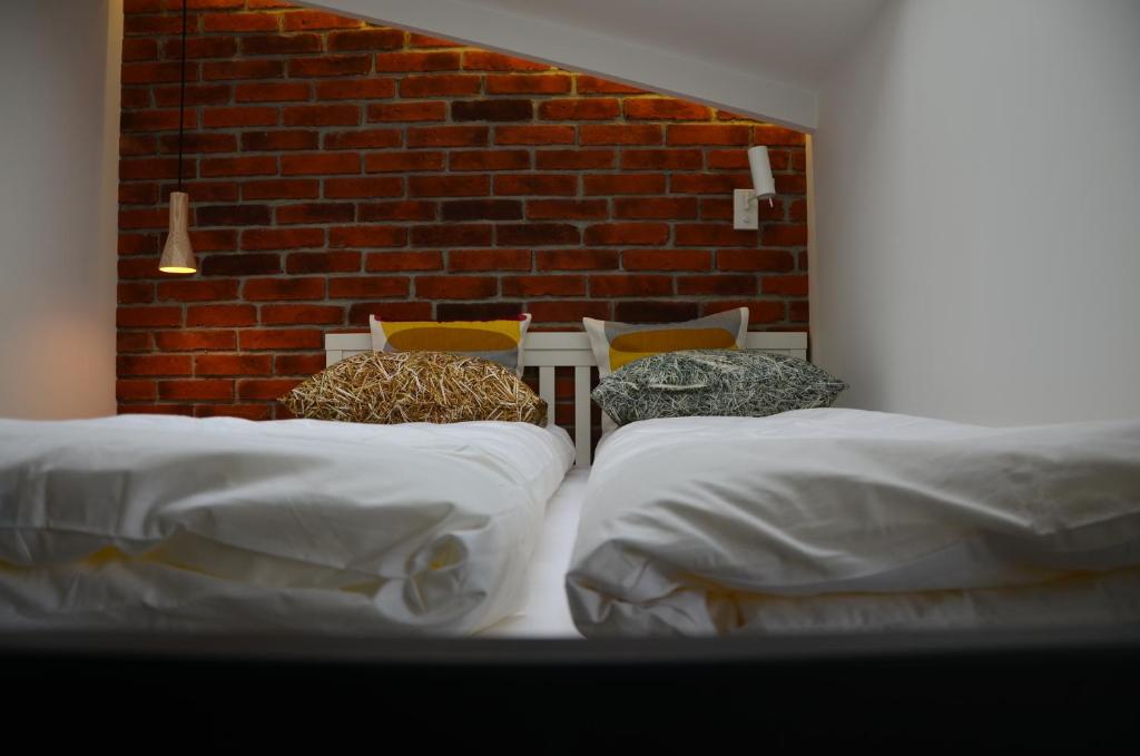 a room with three beds and a brick wall at Apartament Polka Dots in Krakow