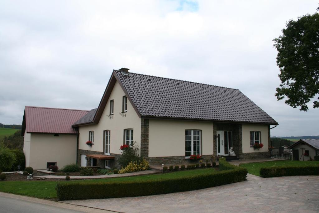 una casa blanca con techo negro en Location PanoramaGreen, en Burg-Reuland