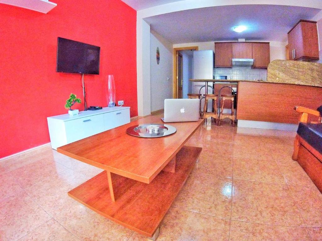 a living room with a table with a laptop on it at Piso 8 Personas Wifi 500Mb in Telde