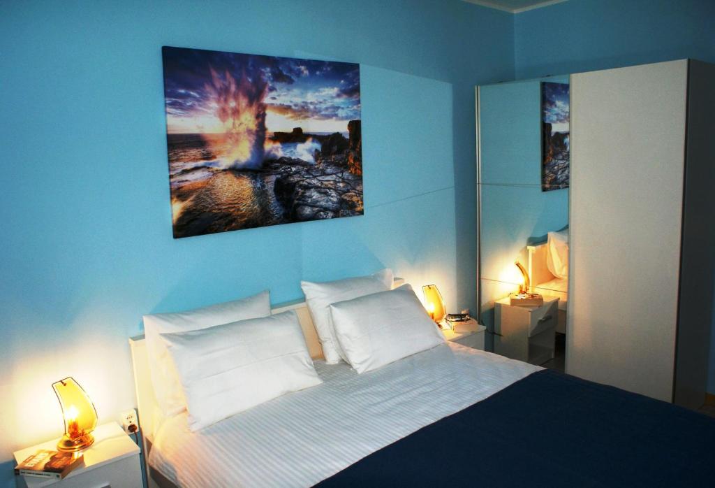 - une chambre bleue avec un lit et deux lampes dans l'établissement PERLA BLEU 4 Apartment, à Rovinj