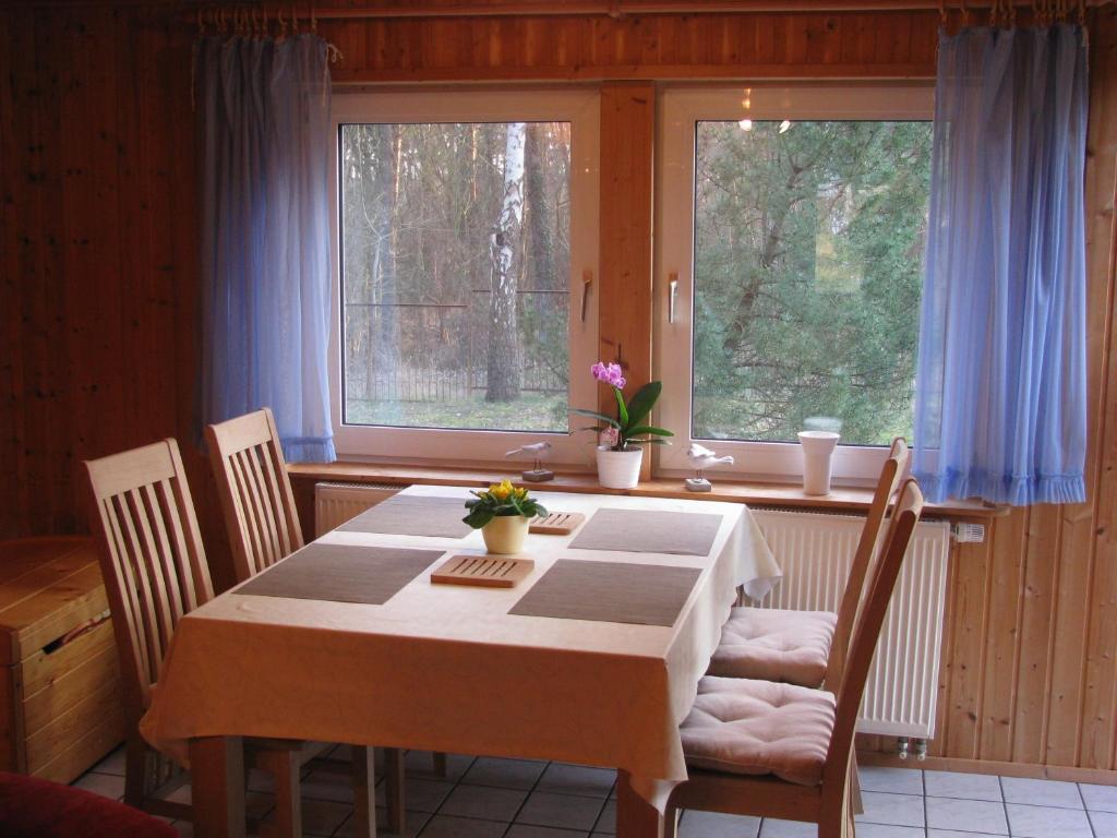 ein Esszimmer mit einem Tisch und 2 Fenstern in der Unterkunft Ferienhaus Troge in Zinnowitz