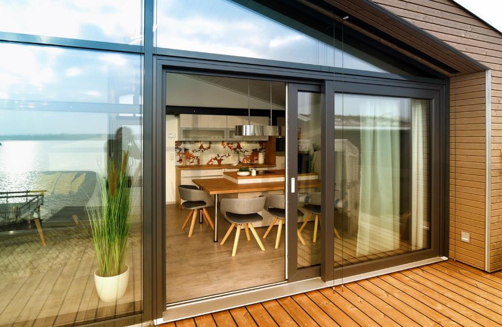 une extension d'une maison avec des portes coulissantes en verre et une salle à manger dans l'établissement PETIT-CHALET AM HAINER SEE, à Rötha