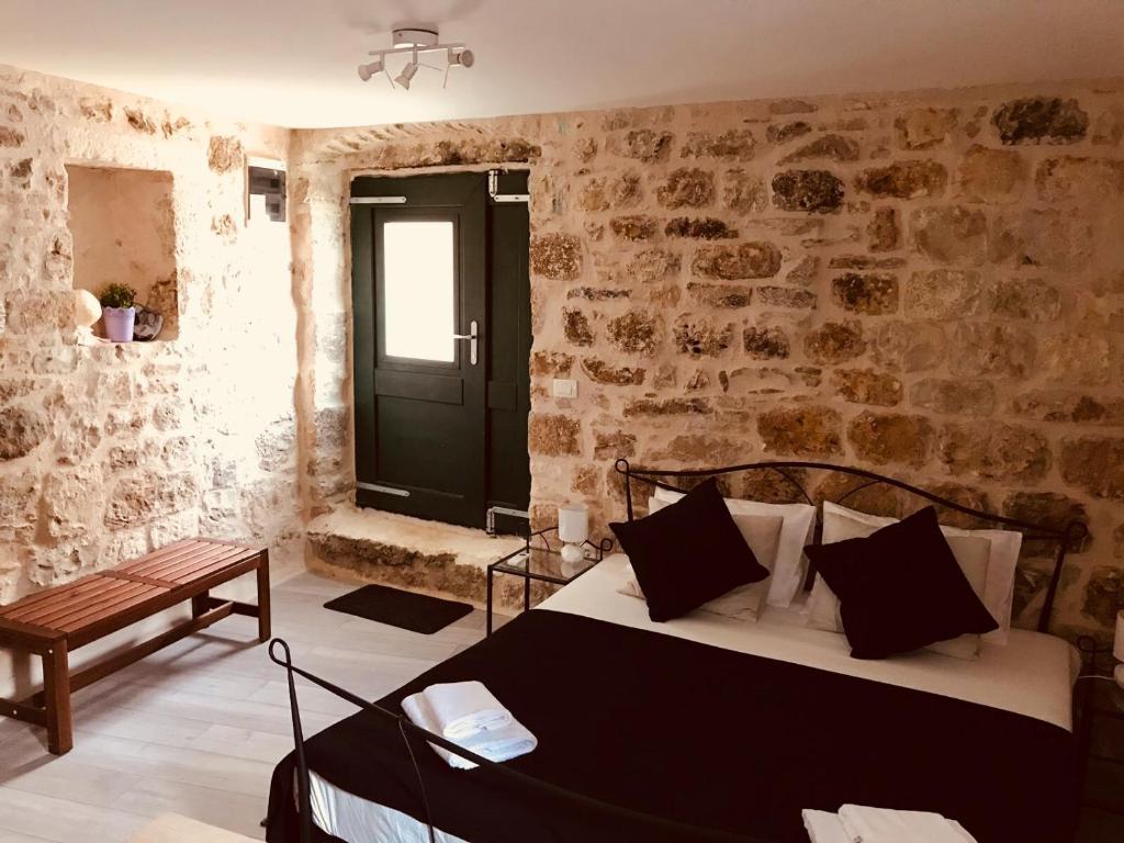 a bedroom with a bed in a room with stone walls at Villa San Marco in Hvar