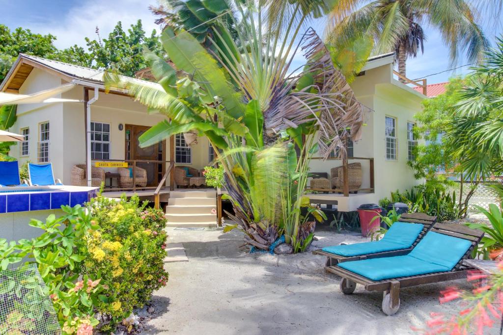 een huis met twee blauwe ligstoelen ervoor bij Amanda's Place Casita Carinosa - pool and tropical garden in Caye Caulker