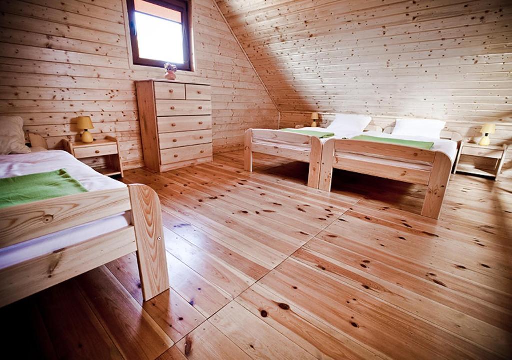 pokój z 2 łóżkami w drewnianym domku w obiekcie Kakadu domki letniskowe Niechorze w mieście Niechorze