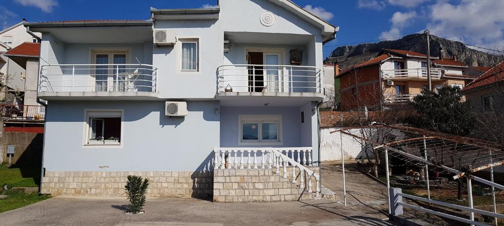 a white house with a balcony on top of it at Apartment and room Panorama in Mostar