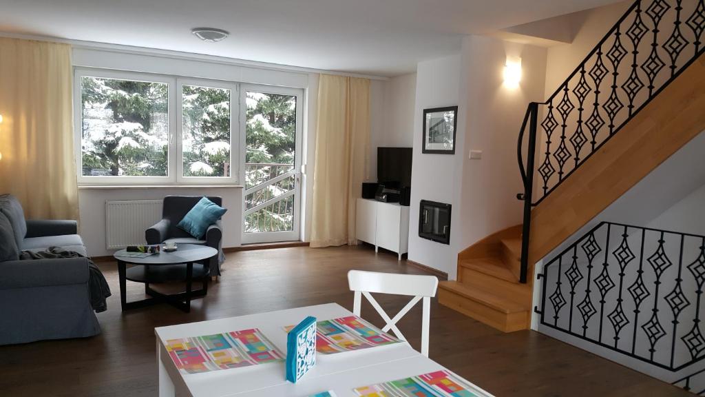 a living room with a stair case and a living room at Apartament rodzinny z ogrodem - Bliżej Zdroju in Polanica-Zdrój