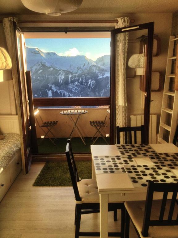 Cette chambre dispose d'une table et offre une vue sur la montagne. dans l'établissement Superbe appart 4/5p balcon plein sud, vue exceptionnelle, retour ski aux pieds, à L'Alpe-d'Huez