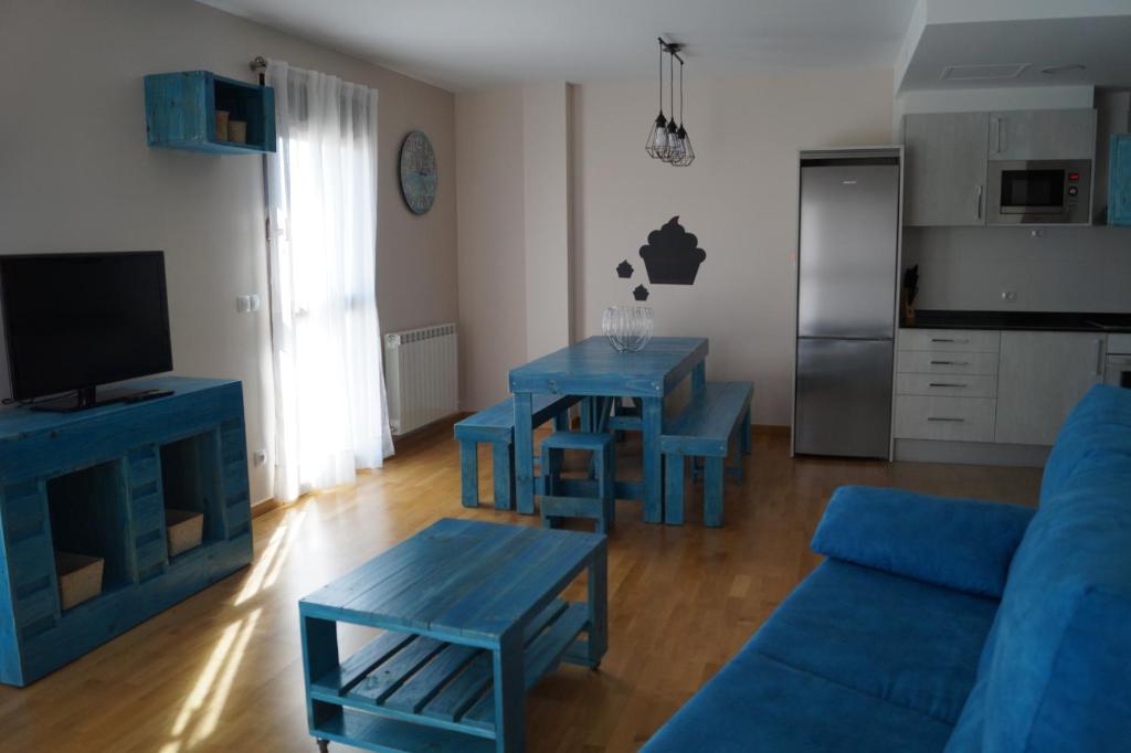 - un salon doté d'un mobilier bleu et d'un canapé bleu dans l'établissement Apartamento Turístico “El Yugo”, à Arguedas