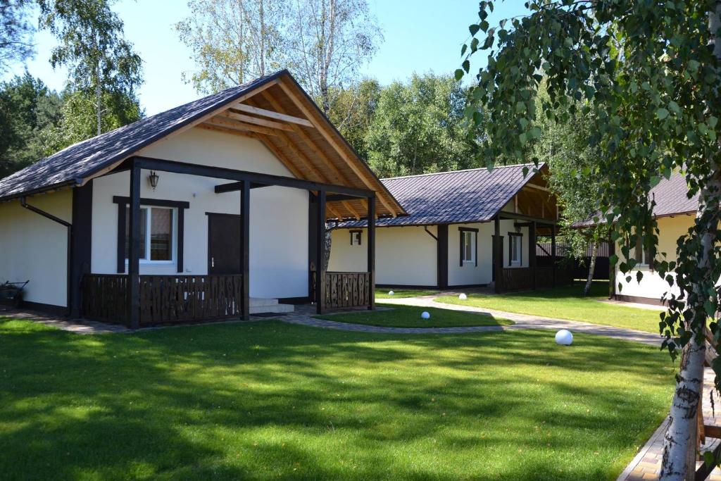 a house with a green yard with two buildings at Клёвое место in Protsev