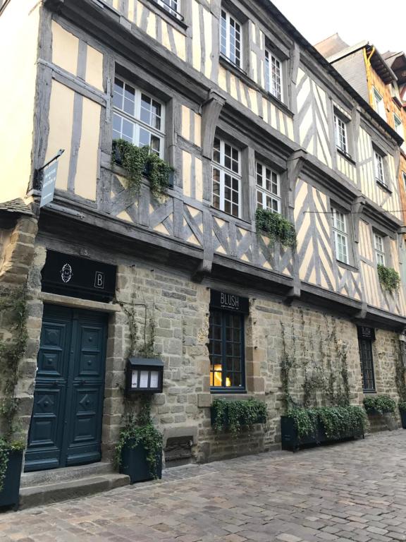 a stone building with a black door and windows at Marnie et Mister H in Rennes