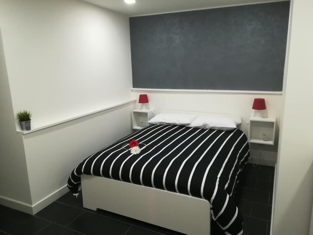 カターニアにあるCasa del Plebiscitoのベッドルーム1室(黒と白のストライプのベッド1台付)
