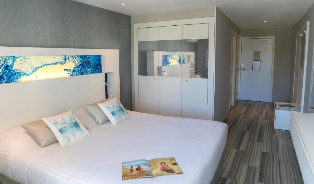 a bedroom with a large white bed with two pillows at Hôtel Josse in Antibes