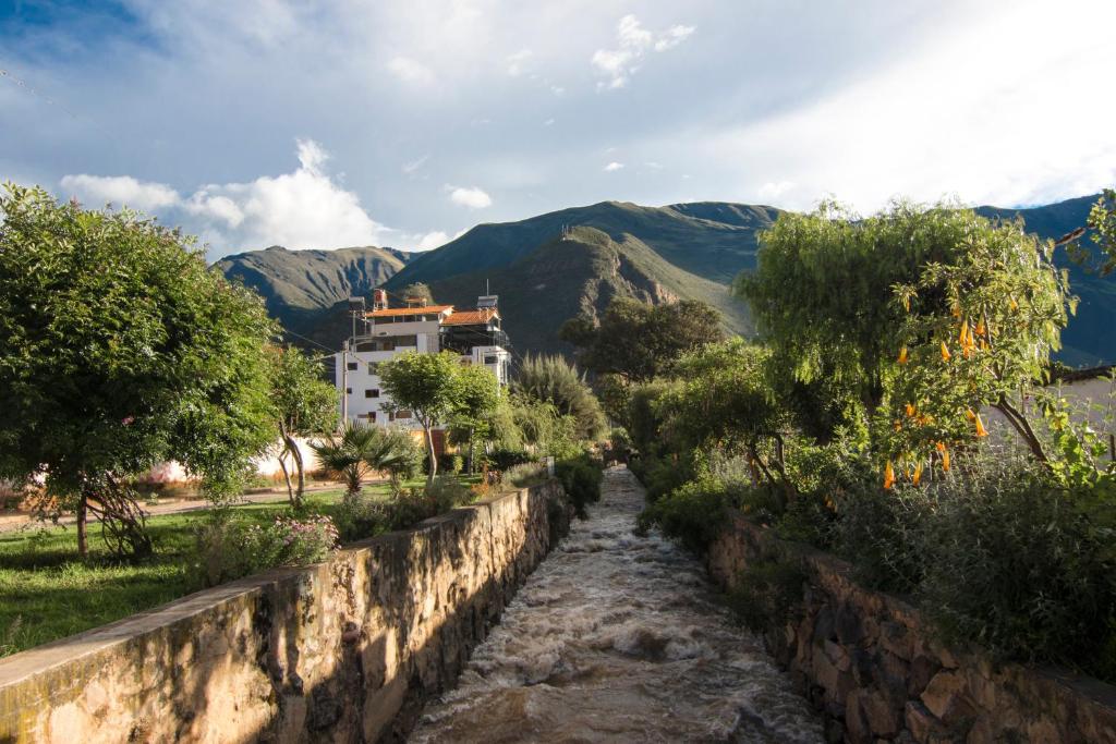 a stone wall with a mountain in the background at Hotel California Calca in Calca