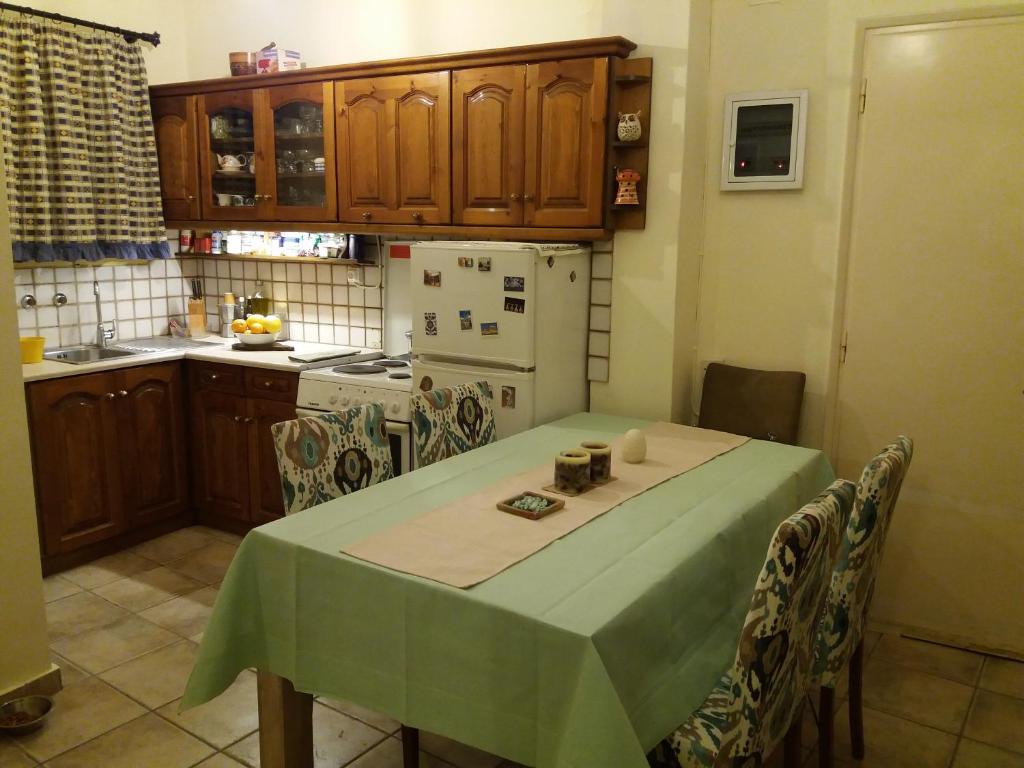 a kitchen with a table with a green table cloth at Cozy Apartment Near Historic Centre in Corfu Town