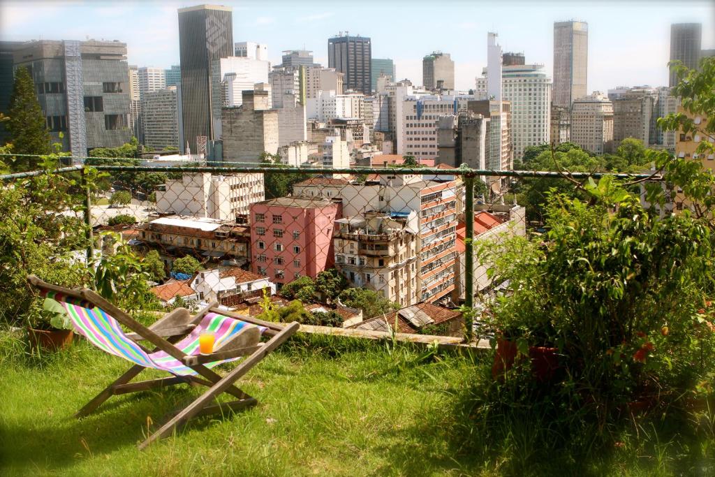 a lawn chair sitting in the grass with a city skyline at Casa da Gente in Rio de Janeiro