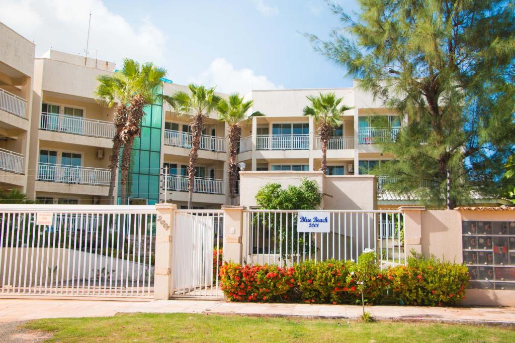 una valla frente a un edificio con palmeras en Blue Beach Temporada, en Aquiraz