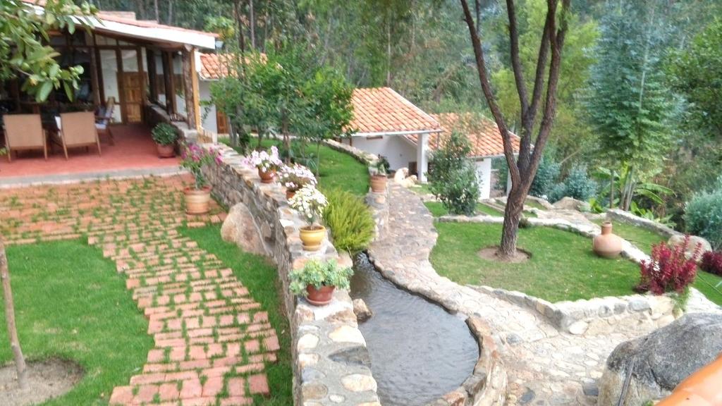 un jardín con un camino de piedra y una casa en Casa Pukayaku Lodge en Caraz