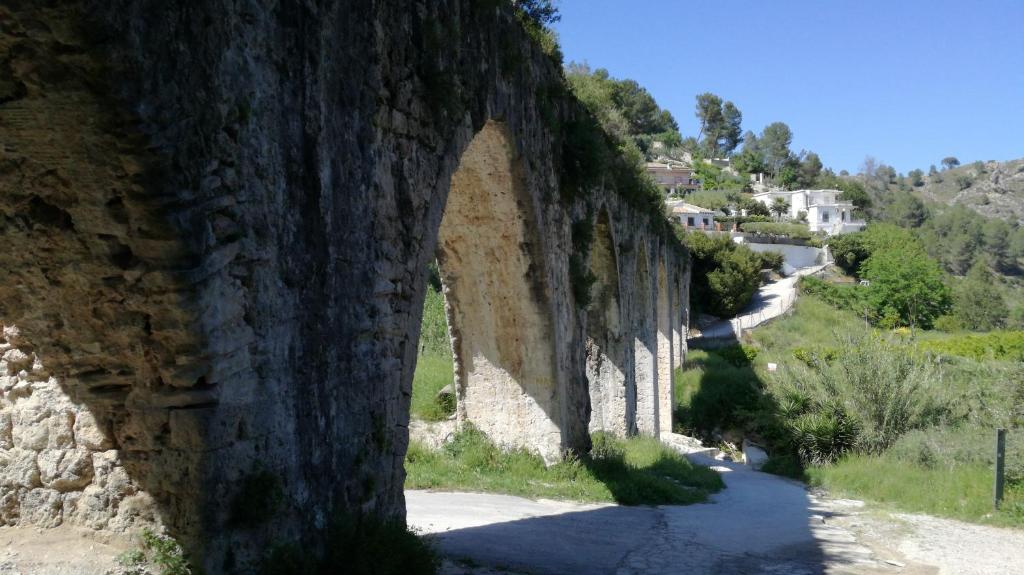 an arch in a stone wall with a road at Casa Rural l'Avia Tica in Benisuera