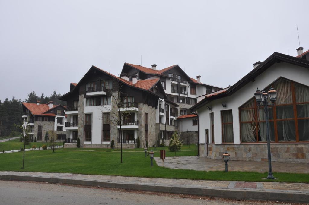 a group of buildings on a street with grass at PM Services Semiramida Apartments in Borovets