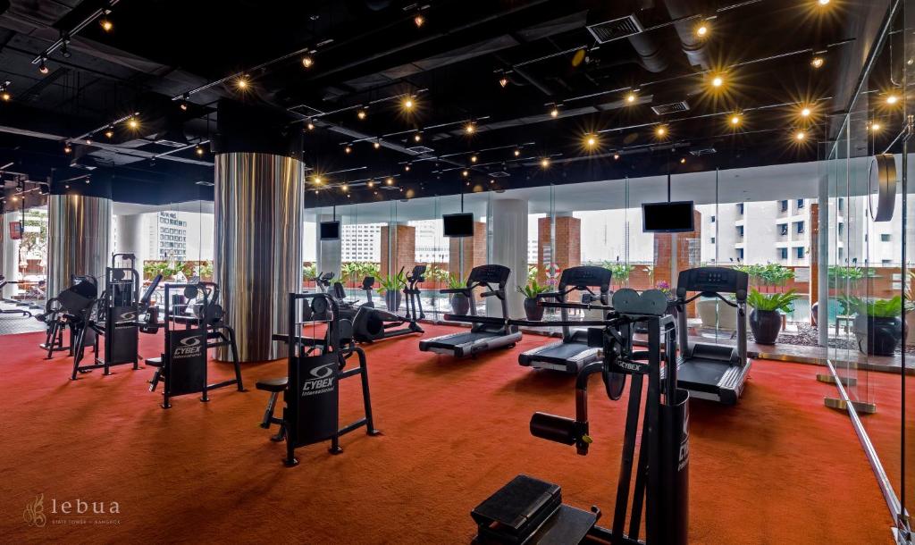 A bright fitness room overlooks the city through broad windows and mirrors.