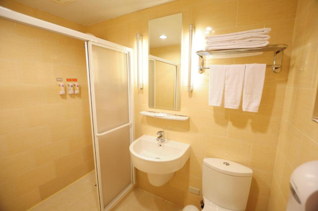 a bathroom with a shower and a toilet and a sink at Kindness Hotel - Jhong Jheng in Kaohsiung