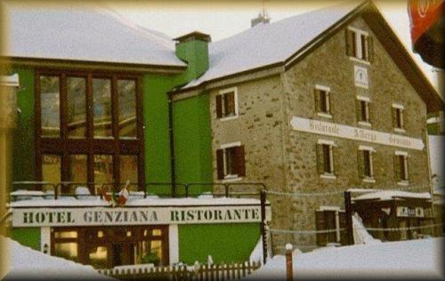 un grand bâtiment avec un panneau devant lui dans l'établissement Hotel Genziana, à Col du Stelvio