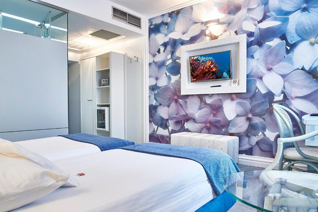 a room with two beds and a tv on a wall at Continental Forum Sibiu in Sibiu