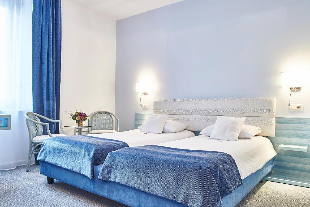a hotel room with a bed and a chair at Continental Forum Sibiu in Sibiu