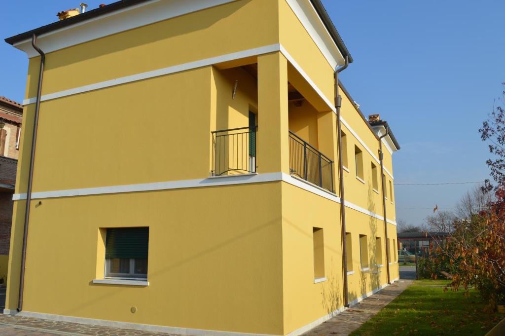 un bâtiment jaune avec des balcons sur son côté dans l'établissement Alloggio Le Macine, à Ferrare
