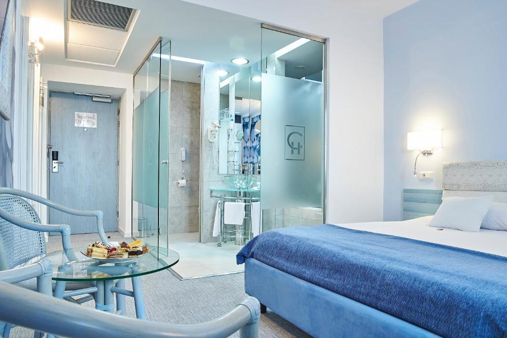 a bedroom with a bed and a table and a glass room at Continental Forum Sibiu in Sibiu