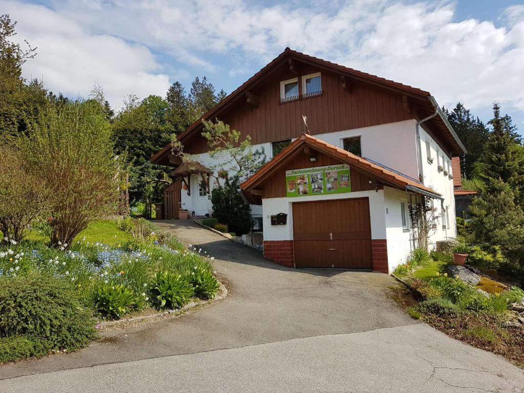 a white house with a brown roof and a driveway at Ferienwohnung Dersch in Mauth