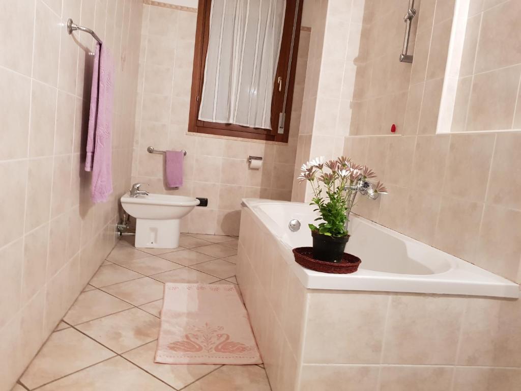 a bathroom with a tub and a toilet and a sink at Alghero Heart in Alghero