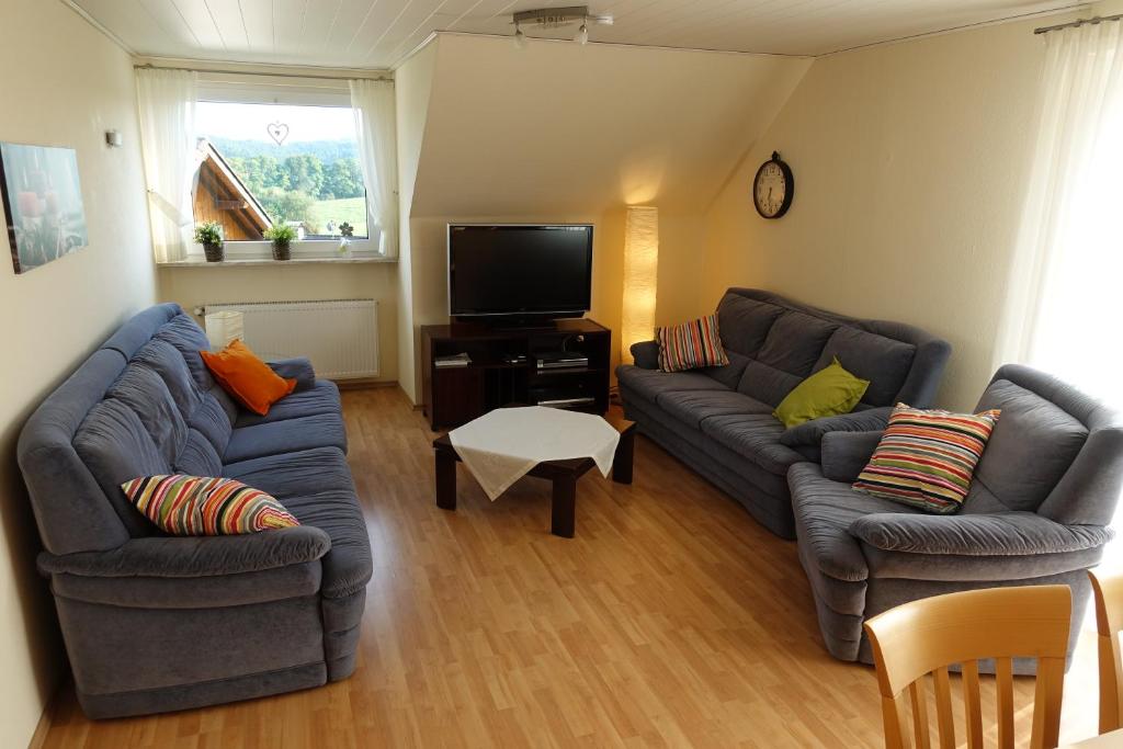 a living room with two couches and a tv at Ferienwohnung Lindlar-Linde in Lindlar