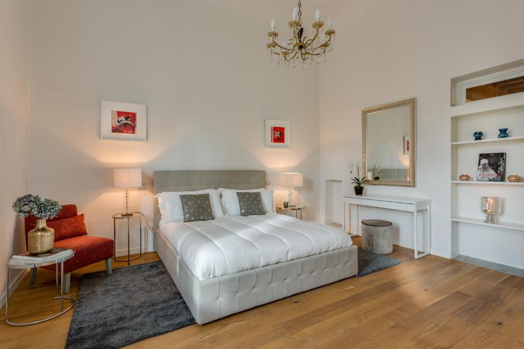 a bedroom with a white bed and a red chair at Apartments Florence - Fortezza in Florence