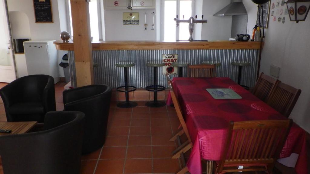 een eetkamer met een rode tafel en stoelen bij Les Gîtes Du Vieux Frêne in Longavesnes