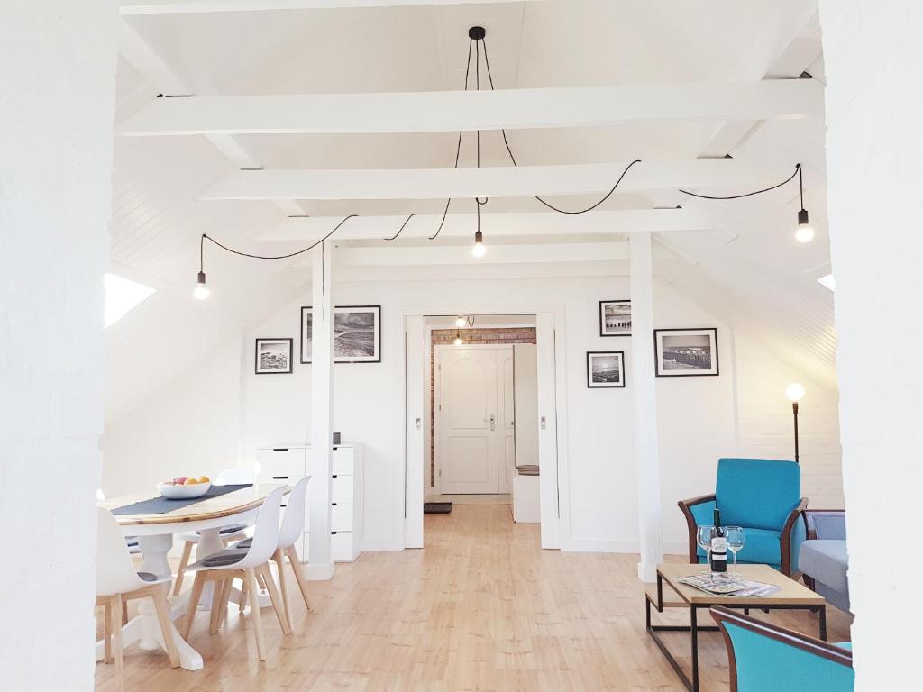 a dining room and living room with a table and chairs at Izba u Jędrusia in Karwia