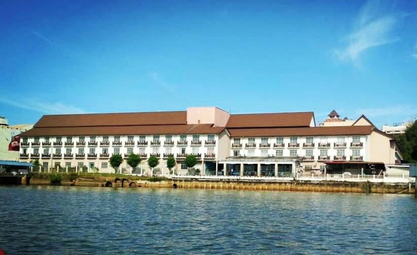 Hotel Seri Malaysia Kuala Terengganu في كوالا ترغكانو: مبنى كبير بجانب تجمع المياه