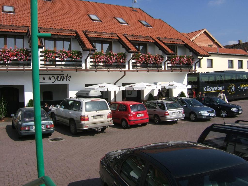 un estacionamiento con autos estacionados frente a un edificio en Hotel YORK, en Plzeň