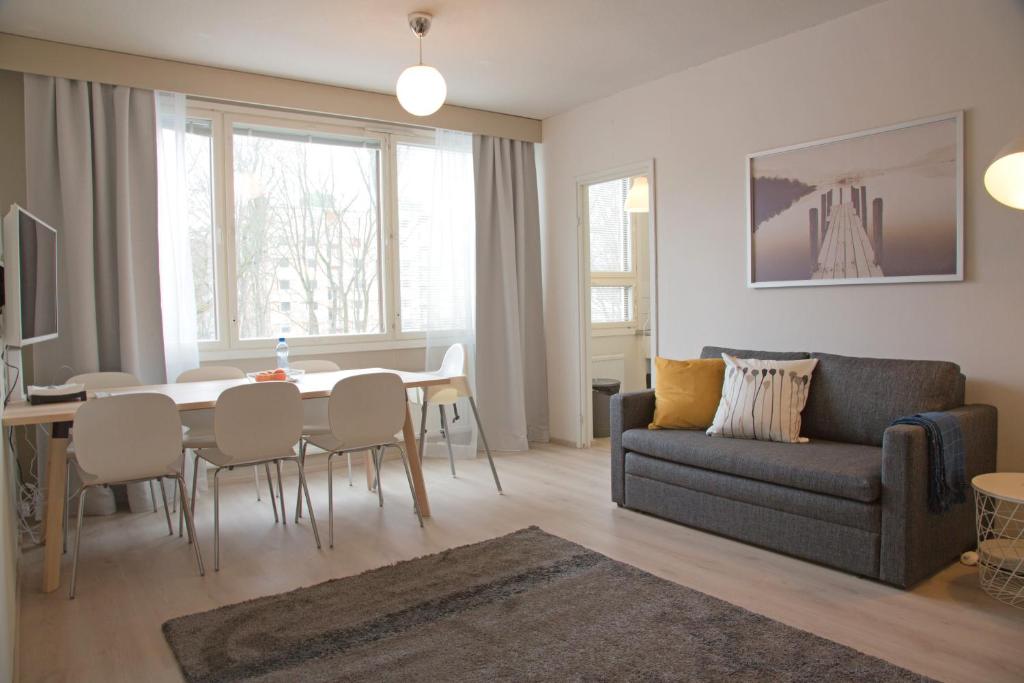 a living room with a couch and a table at Borent Suite Family in Turku