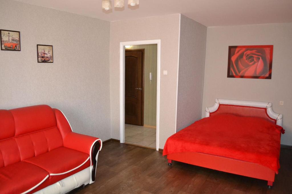 ザポリージャにあるApartment Universitetskaya 54のベッドルーム(赤いベッド1台、ソファ付)