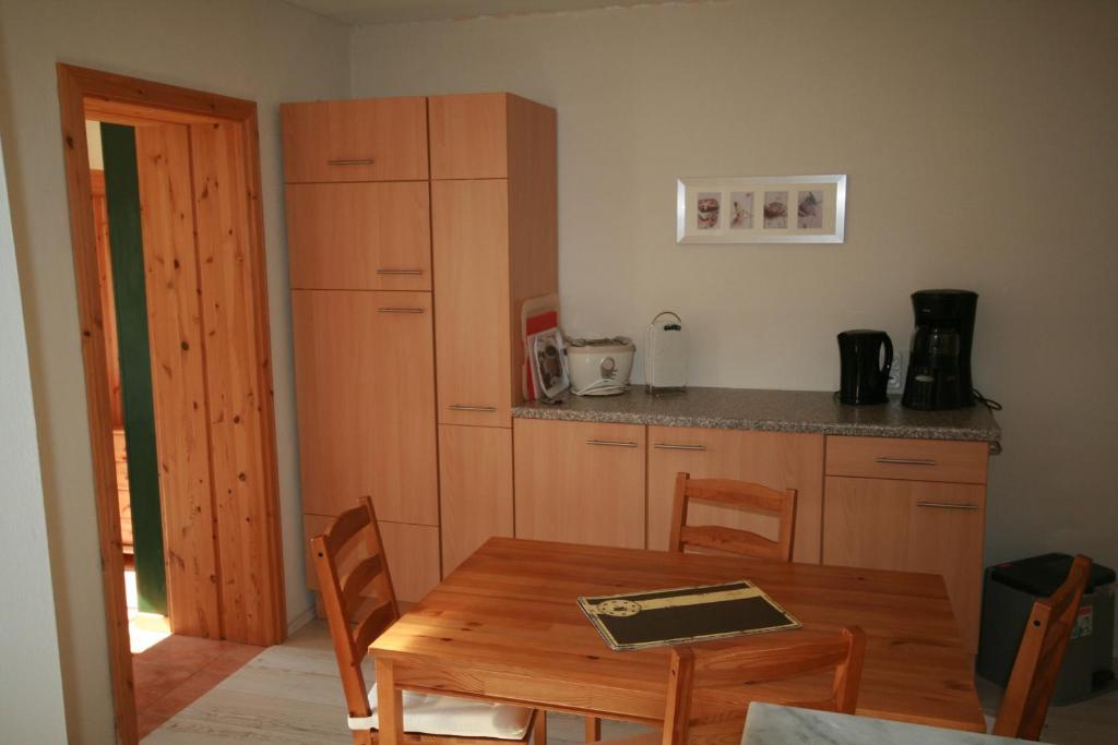 a kitchen with a wooden table and a dining room at Landhaus Chlosta in Büttelkow