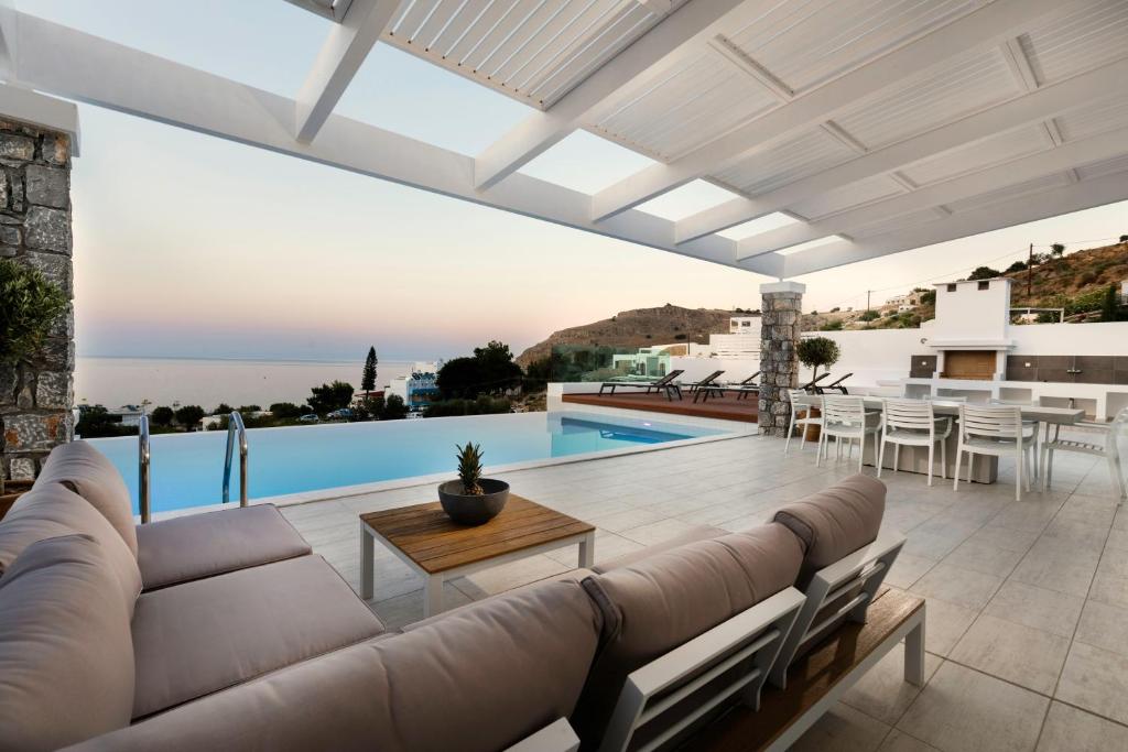 a living room with a couch and a table at Villa Serene with swimming pool in Lindos in Líndos