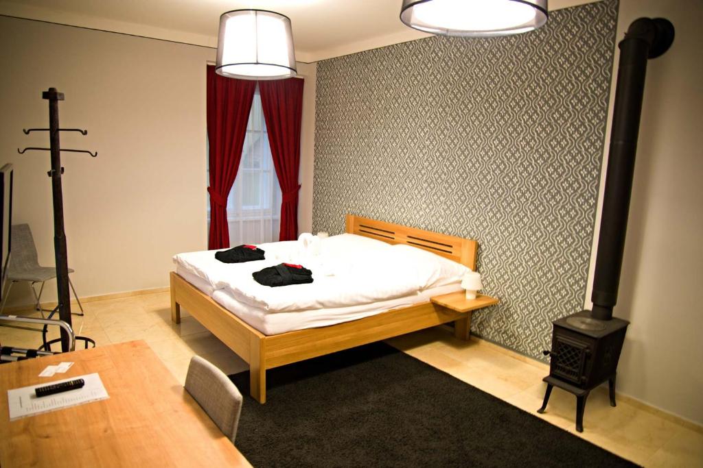 um quarto com uma cama e um fogão a lenha em Penzion U tri statkaru em Dobříš