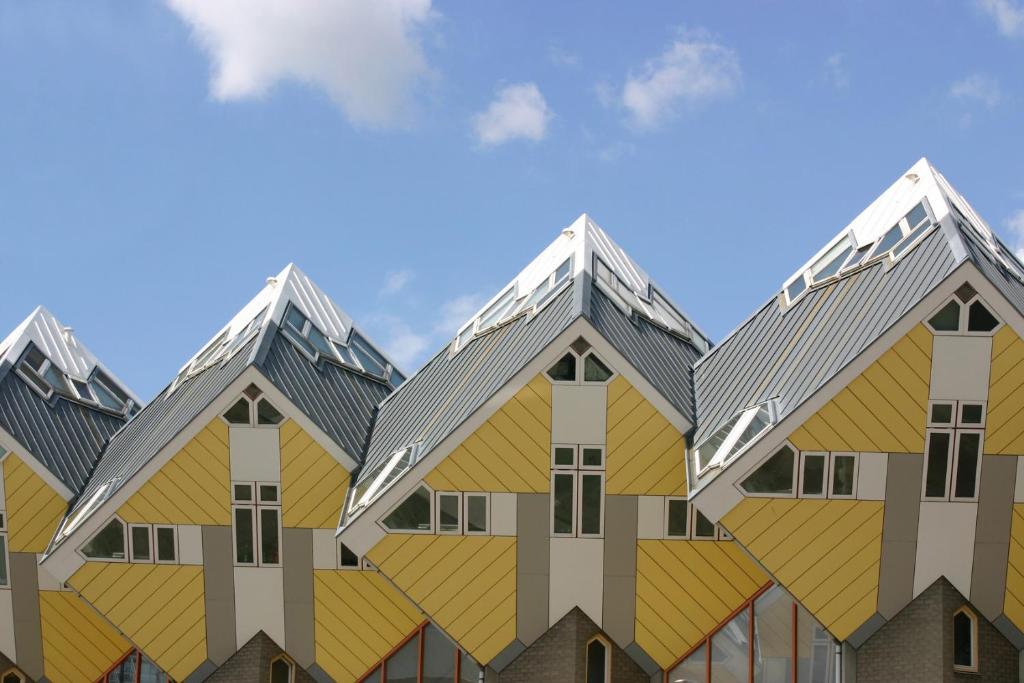 
a row of yellow and white buildings with a sky background at Stayokay Hostel Rotterdam in Rotterdam
