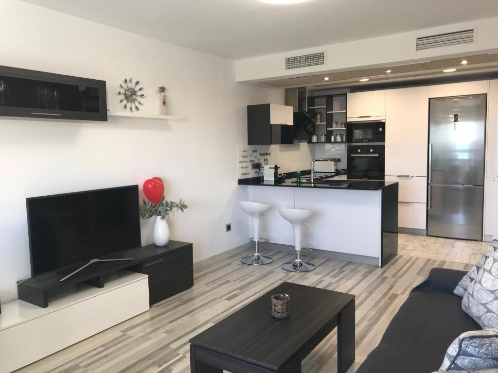 een woonkamer met een bank en een keuken bij Las Brisas Del Mediterráneo in Alicante